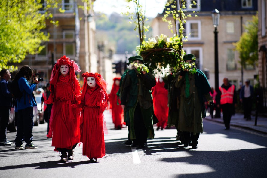 Os Rebeldes Vermelhos participam de uma procissão de um funeral pela natureza em Bath, na Inglaterra, para marcar o declínio do mundo natural antes do Dia da Terra de 2024