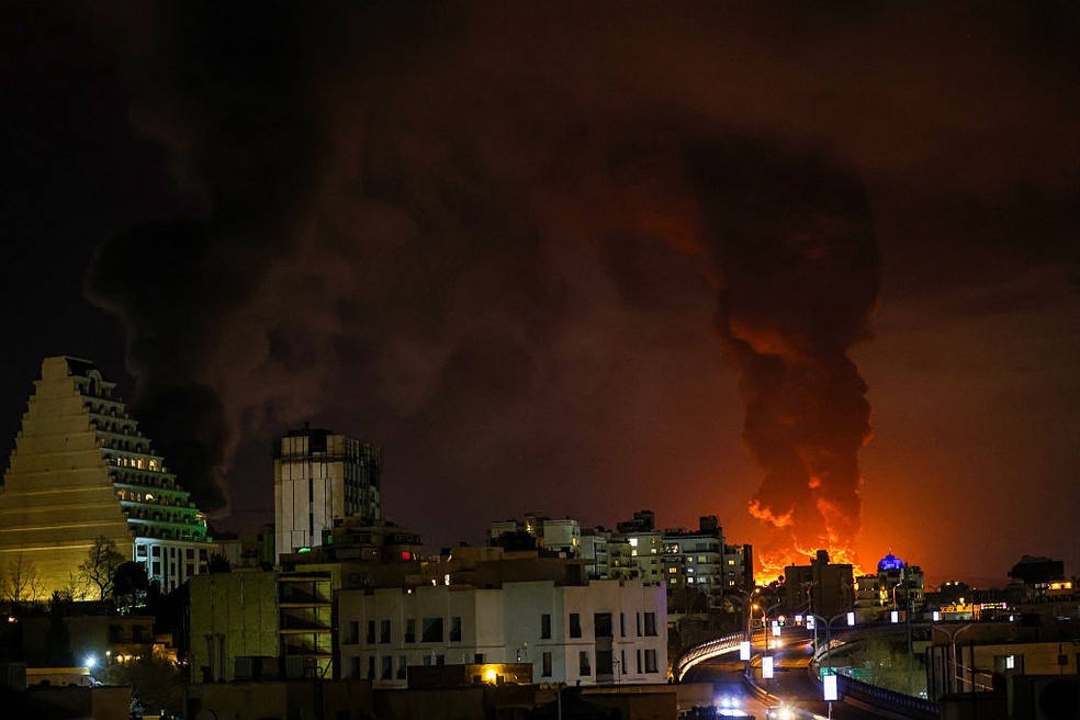 Uma grande coluna de fumaça se eleva sobre Teerã após explosões serem relatadas na cidade durante a noite de 7 de março de 2026, em Teerã, Irã. — Foto: Contributor/Getty Images