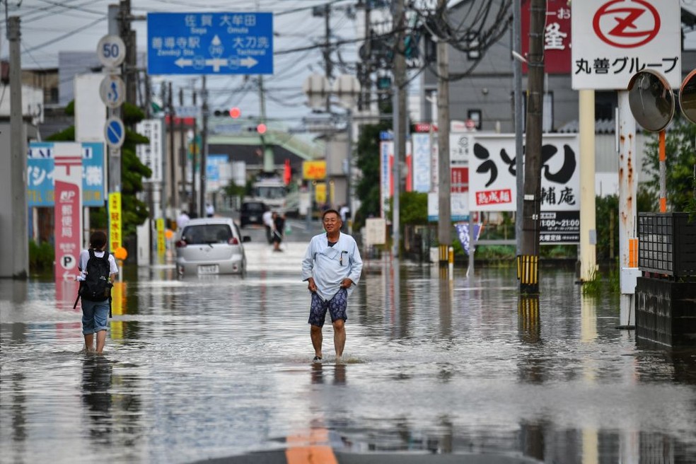 Um homem atravessa uma rua inundada na cidade de Kurume, Fukuoka, no Japão — Foto: Getty Images