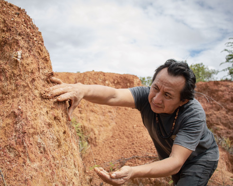 Elton retira barro para mostrar a textura que ele tem. A região tem barro de diferentes cores — Foto: Amanda Magnani