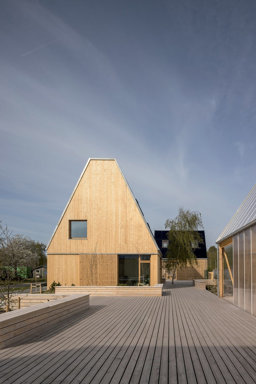 O visual externo da mesma casa, com estrutura de madeira