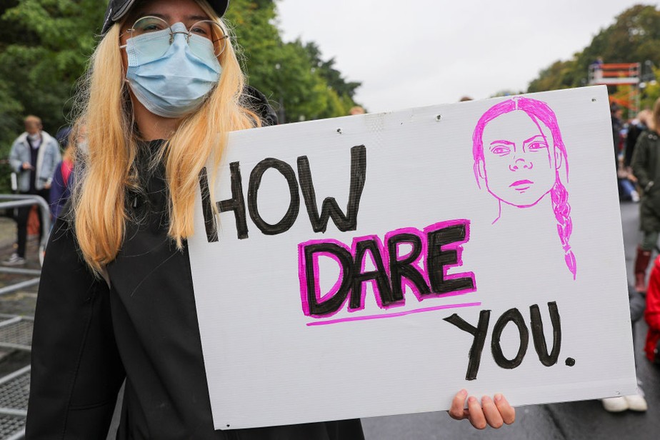 Menina carrega cartaz com frase de Greta Thunberg