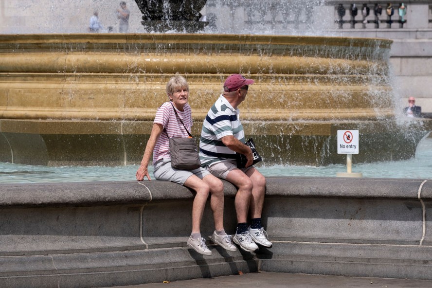 Turistas se refrescam na Trafalgar Square, em Londres