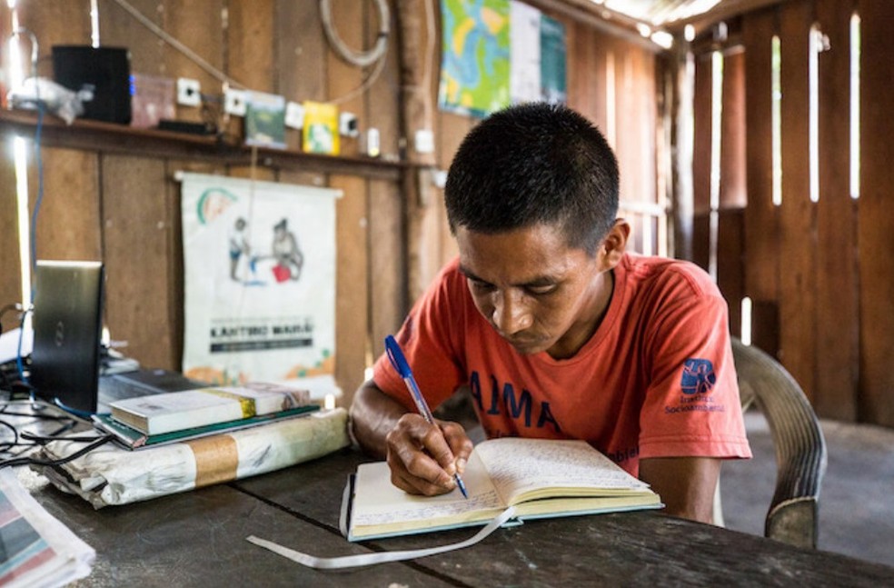 Rosivaldo Miranda, do povo Piratapuya, após um dia de observações e vivência na floresta, faz anotações em seu diário de agente indígena de manejo ambiental — Foto: Fellipe Abreu / National Geographic