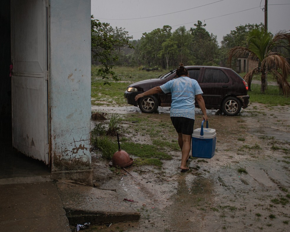 Andreia takes the ice box to the tuxaua's car.  — Photo: Amanda Magnani