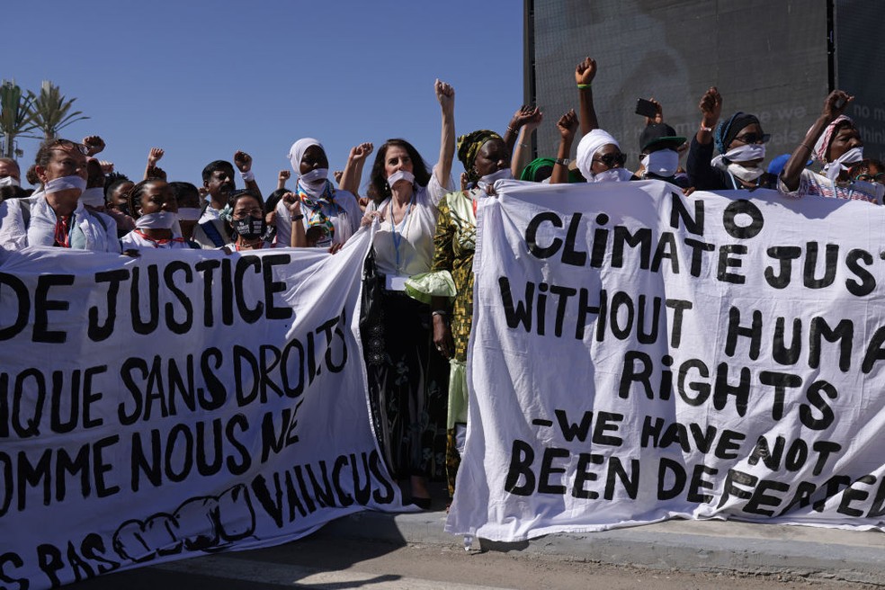 Manifestantes usando mordaças participam de um protesto para exigir liberdade para ativistas de direitos humanos e ambientais presos em todo o mundo durante COP27 — Foto: Getty Images