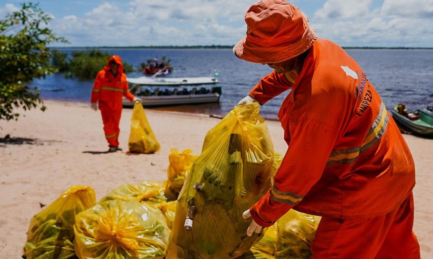 Coleta de lixo plástico em praia no Brasil.