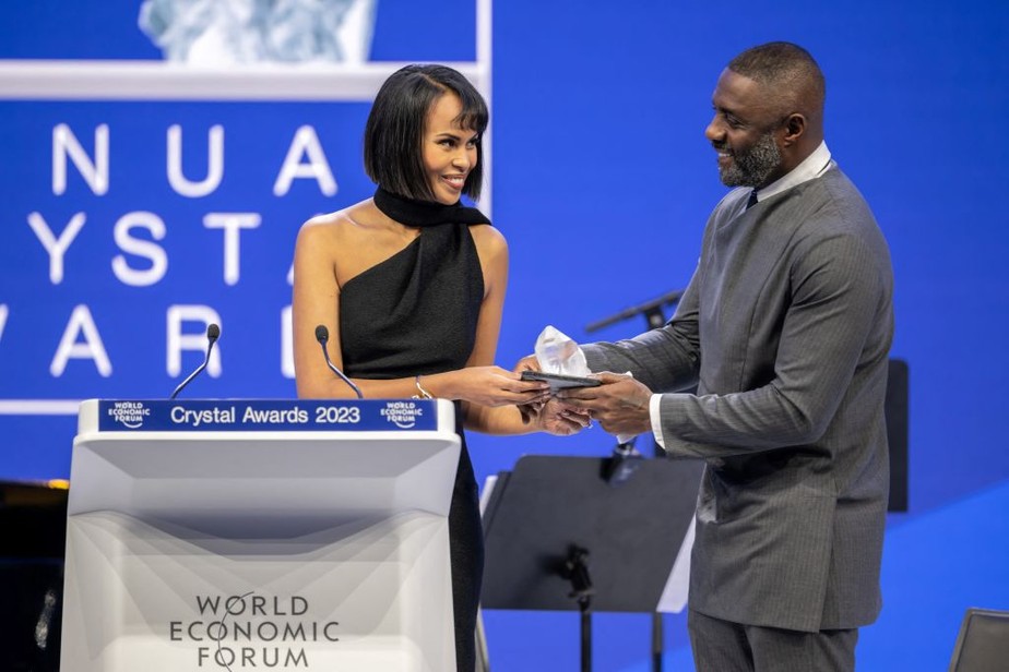 A ativista Sabrina Dhowre Elba e seu marido, o ator Idris Elba, seguram o troféu durante a cerimônia do 'Crystal Award' no Fórum Econômico Mundial