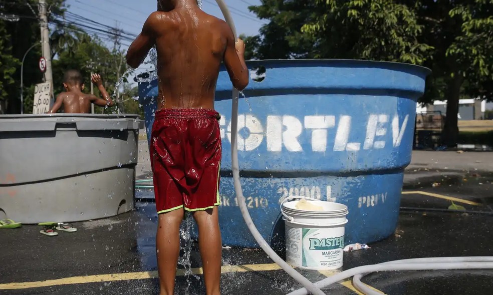 Meninos se molhando em dia de calor forte no Rio de Janeiro. — Foto: Fernando Frazão/Agência Brasil