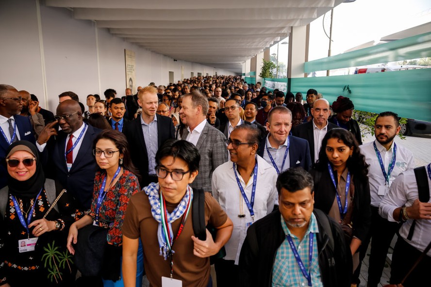 Participantes credenciados aguardam em fila para entrar na COP28, no Centro de Exposições de Dubai.