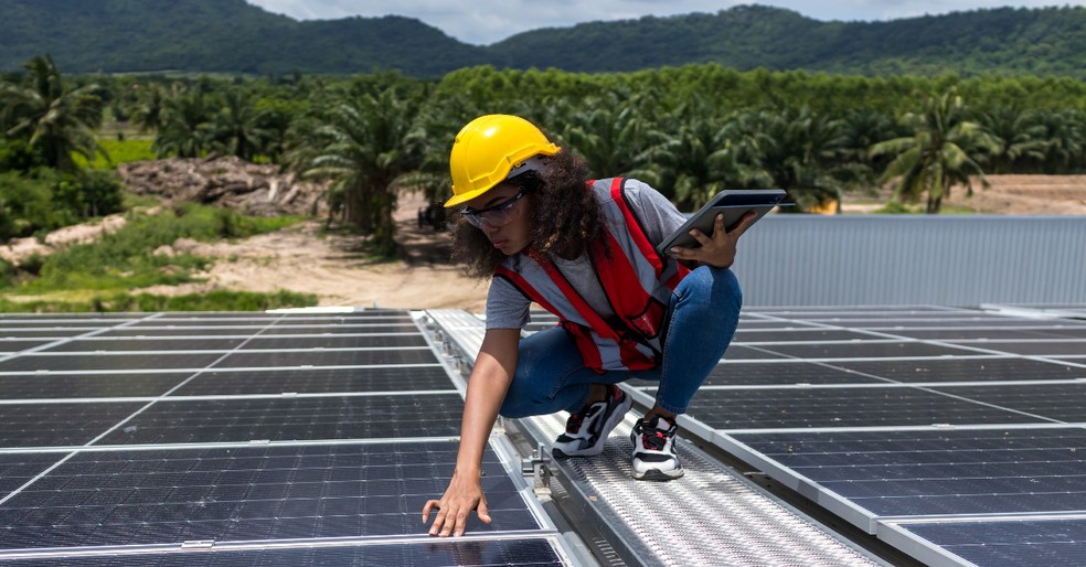 Jovem profissional vistoria placas fotovoltaicas.  — Foto: Divulgação/IRENA