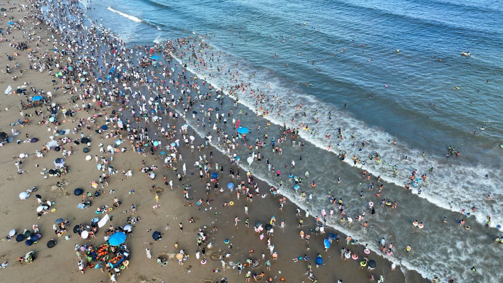 Turistas escapam do calor do verão em praia na China. País teve em julho seu dia mais quente já registrado — Foto: CFOTO/Future Publishing via Getty Images