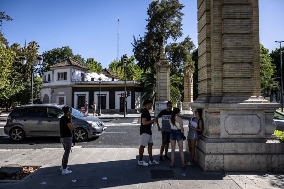 Pedestres esperam na sombra em dia de calorão em Sevilha, Espanha — Foto: Getty Images