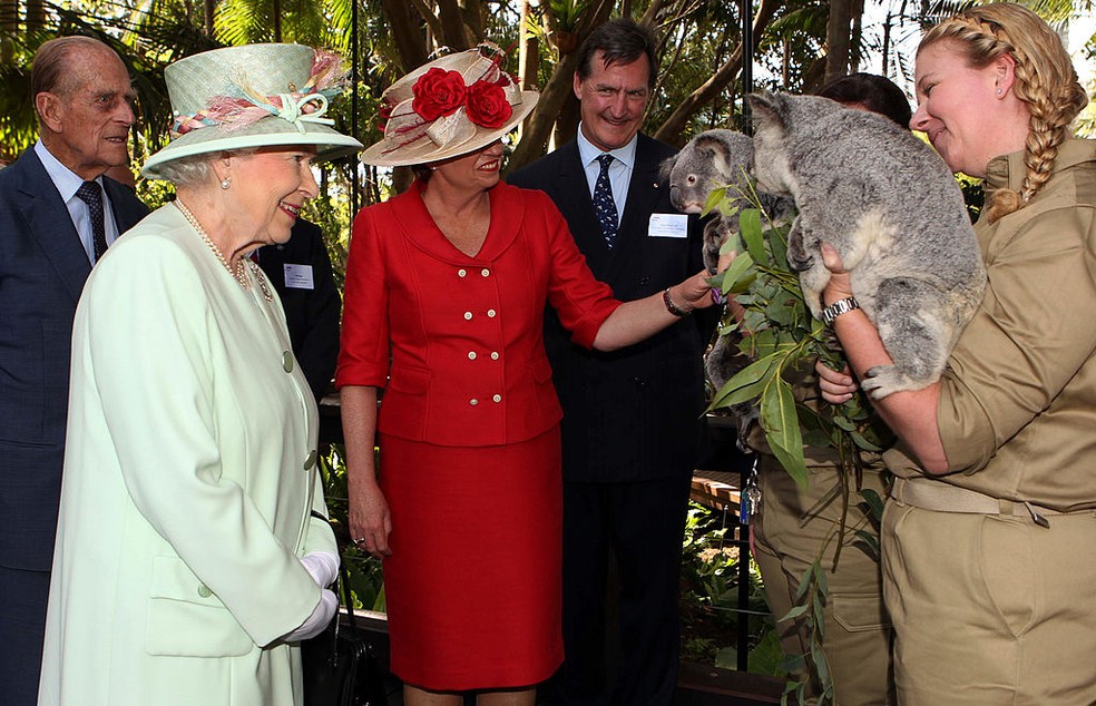 A então primeira-ministra de Queensland, na Austrália, mostra um coala à rainha Elizabeth II durante uma visita a Rainforest Walk, em 2011 — Foto: Getty Images