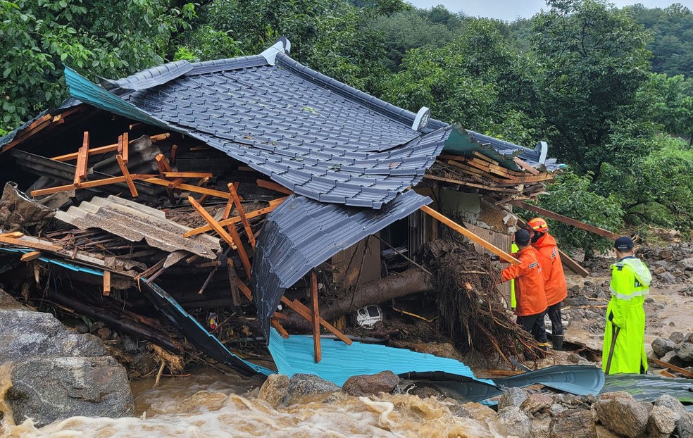 Equipes de emergência sul-coreanas procuram sobreviventes em uma casa destruída por enchentes após fortes chuvas na província de Gyeongsang do Norte — Foto: Getty Images