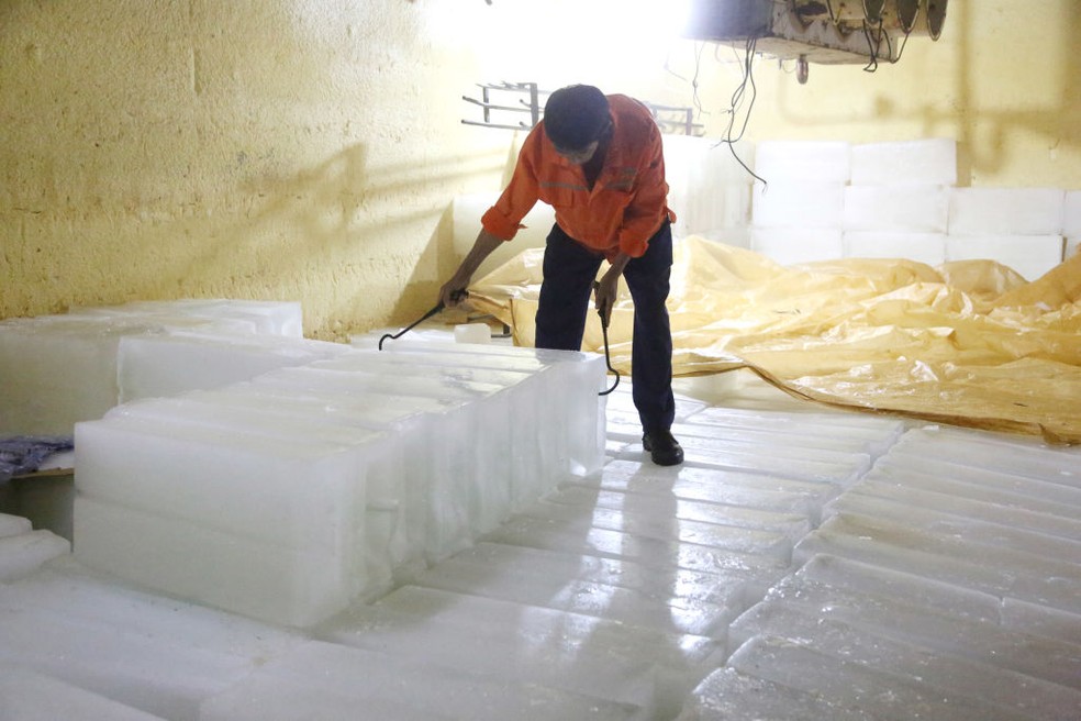Um trabalhador processa cubos de gelo em uma fábrica na cidade de Lianyungang, província de Jiangsu, leste da China, em 14 de julho — Foto: Getty Images