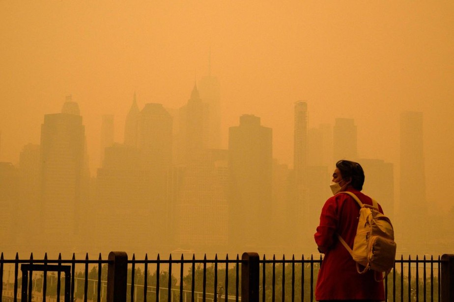 Uma pessoa usa uma máscara facial enquanto a fumaça dos incêndios florestais no Canadá causa condições nebulosas na cidade de Nova York
