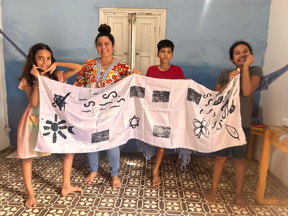Cíntia exibe um dos trabalhos com os seus alunos — Foto: Divulgação