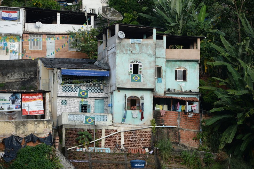 Construções improvisadas em encostas são um dos fatores que expõem favelas a eventos extremos do clima, como chuvas concentradas. Na foto, favela de Salvador se enfeitava para a Copa-2014 no Brasil. — Foto: Marcus Brandt/picture alliance via Getty Images