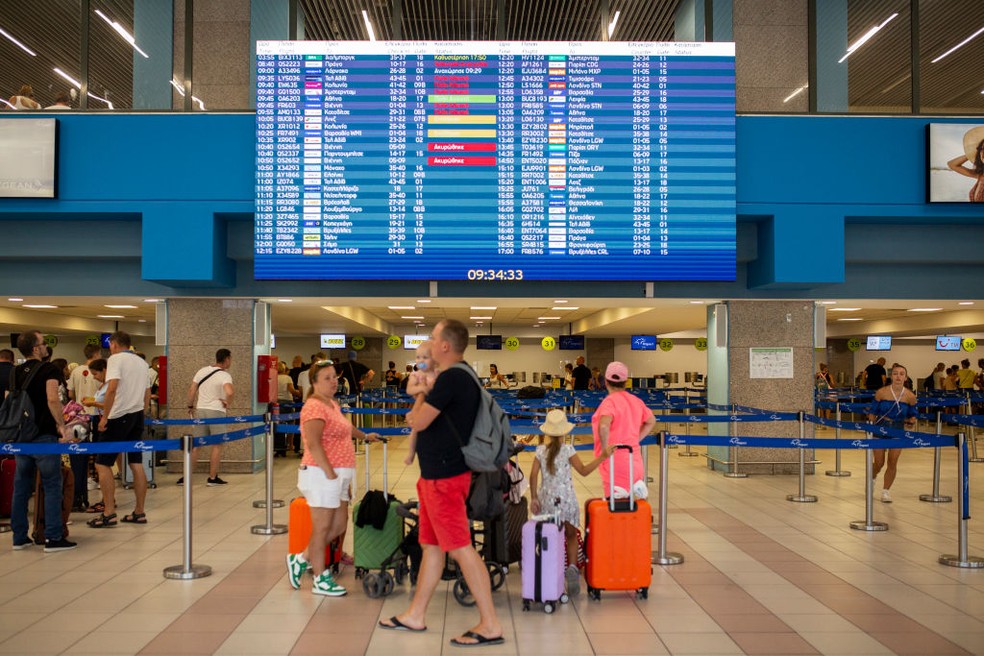Turistas aguardam voo no Aeroporto Internacional de Diagoras, em Rodes, na Grécia, afetada por graves incêndios florestais neste verão do hemisfério norte — Foto: Getty Images