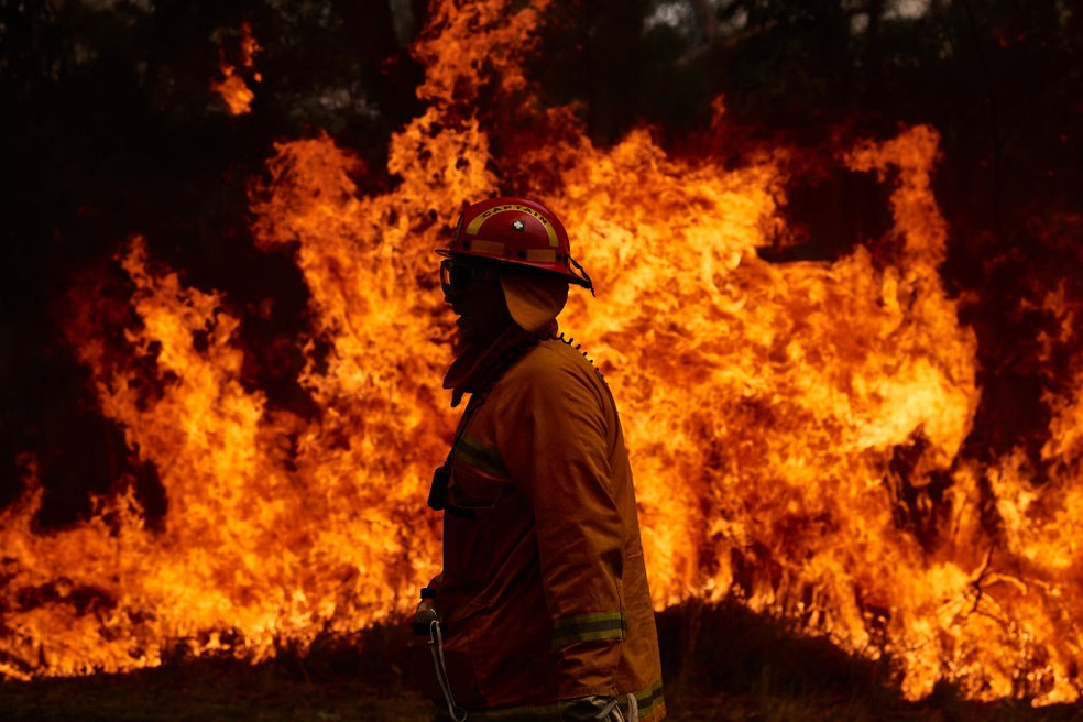Bombeiro tenta controlar incêndio em Sydney, na Austrália, em 2019: incêndios florestais mais frequentes e intensos são consequência de um mundo em aquecimento — Foto: Brett Hemmings/Getty Images
