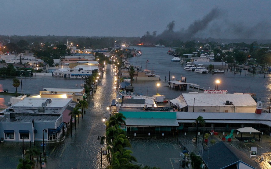 Em uma vista aérea, um incêndio é visto enquanto as enchentes inundam o centro de Tarpon Spirngs após a passagem do furacão Idalia no mar em 30 de agosto
