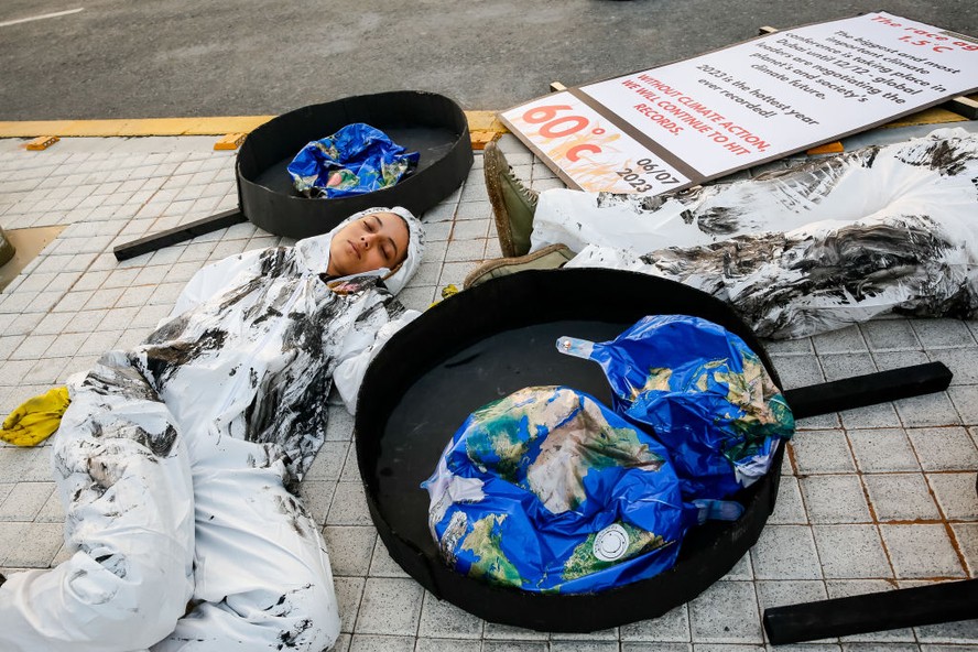 Ativistas encenam protesto contra combustíveis fósseis na COP28, em Dubai.